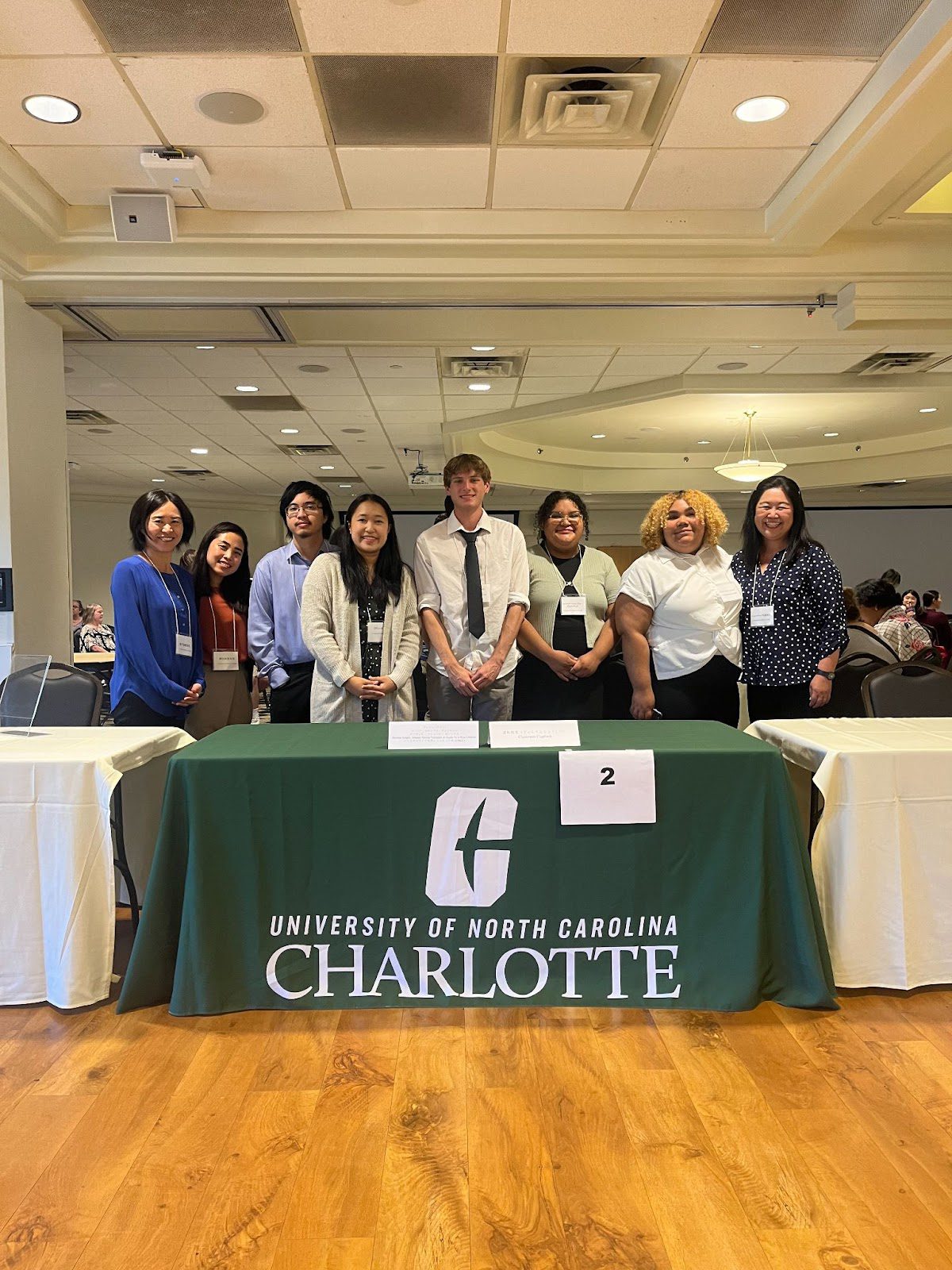 Photo of students and faculty at the NC Showcase standing behind a table.