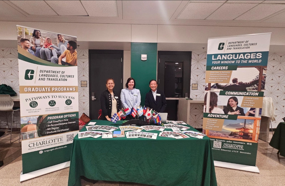 Image of three faculty members in between posters with flags and flyers for students